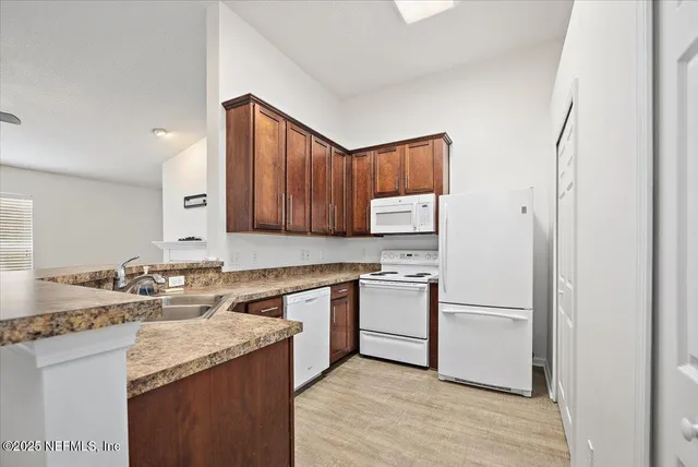 a kitchen with a sink a stove a refrigerator and cabinets