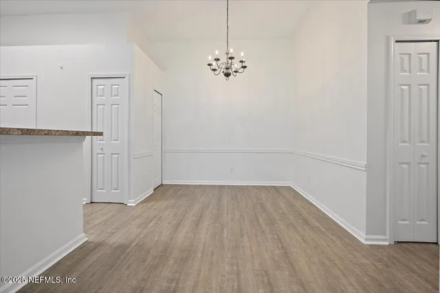 a view of a room with wooden floor and chandelier