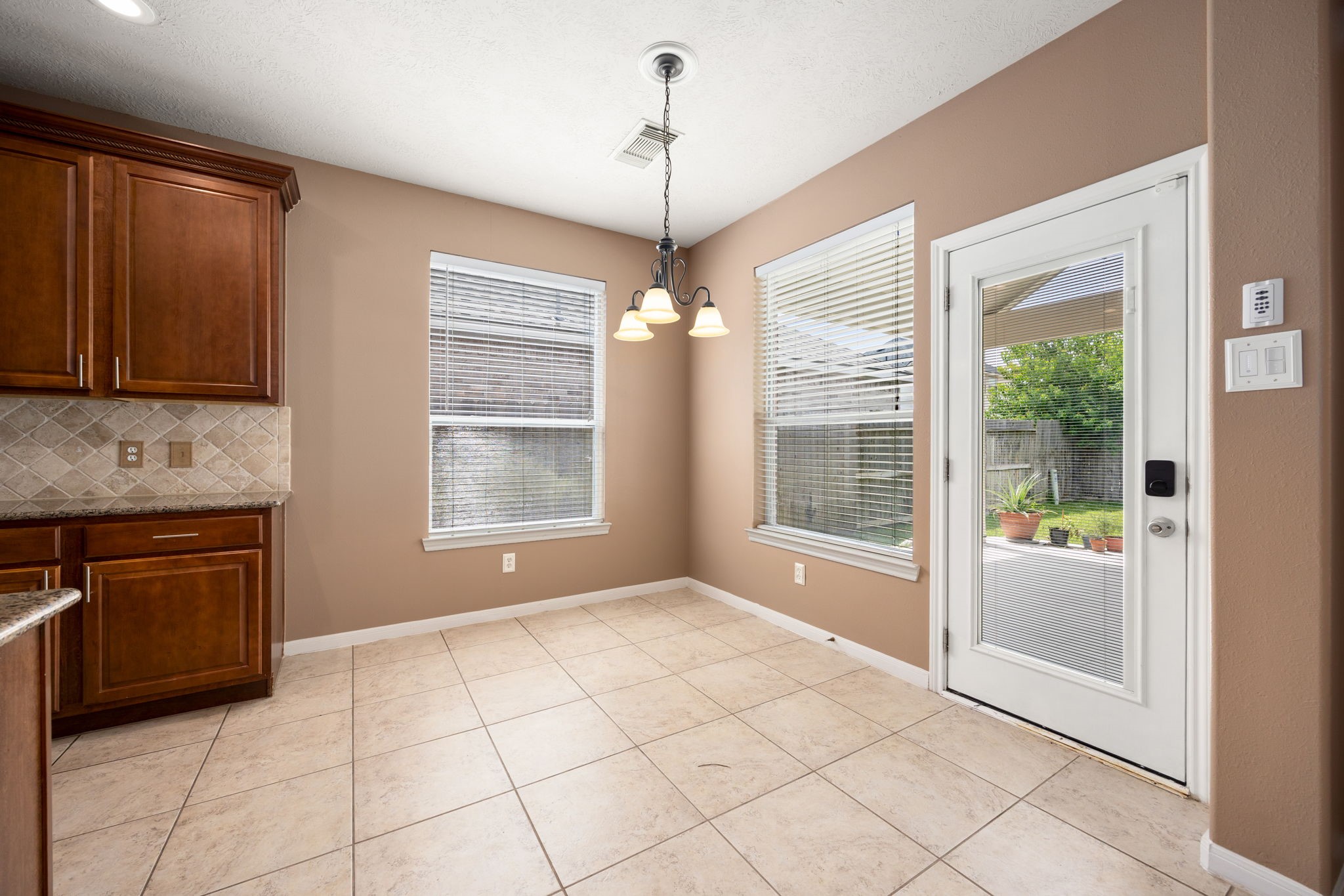 4526 Countrypines Drive Spring, TX 77388 - Photo 21 of 38 Enjoy casual meals in this sunlit breakfast nook located right off the kitchen. Surrounded by large windows and a glass door, it offers peaceful views and seamless access to the backyard patio, perfect for morning coffee.