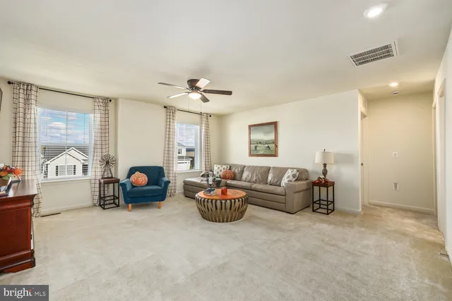 a living room with furniture and a ceiling fan