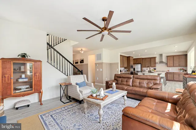 a living room with furniture a ceiling fan and a window