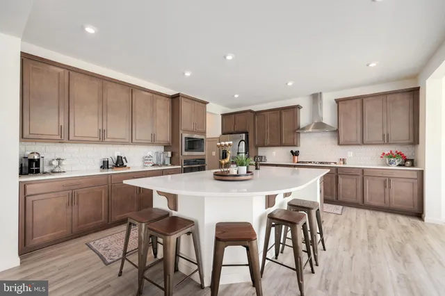 a kitchen with stainless steel appliances kitchen island granite countertop a stove a sink a refrigerator and cabinets