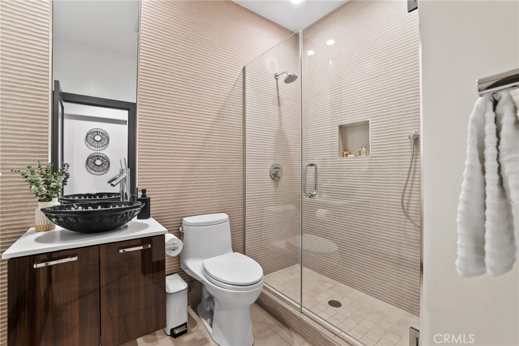 10372 South Crawford Canyon Road Santa Ana, CA 92705 - Photo 46 of 75 a bathroom with a toilet a sink and glass door
