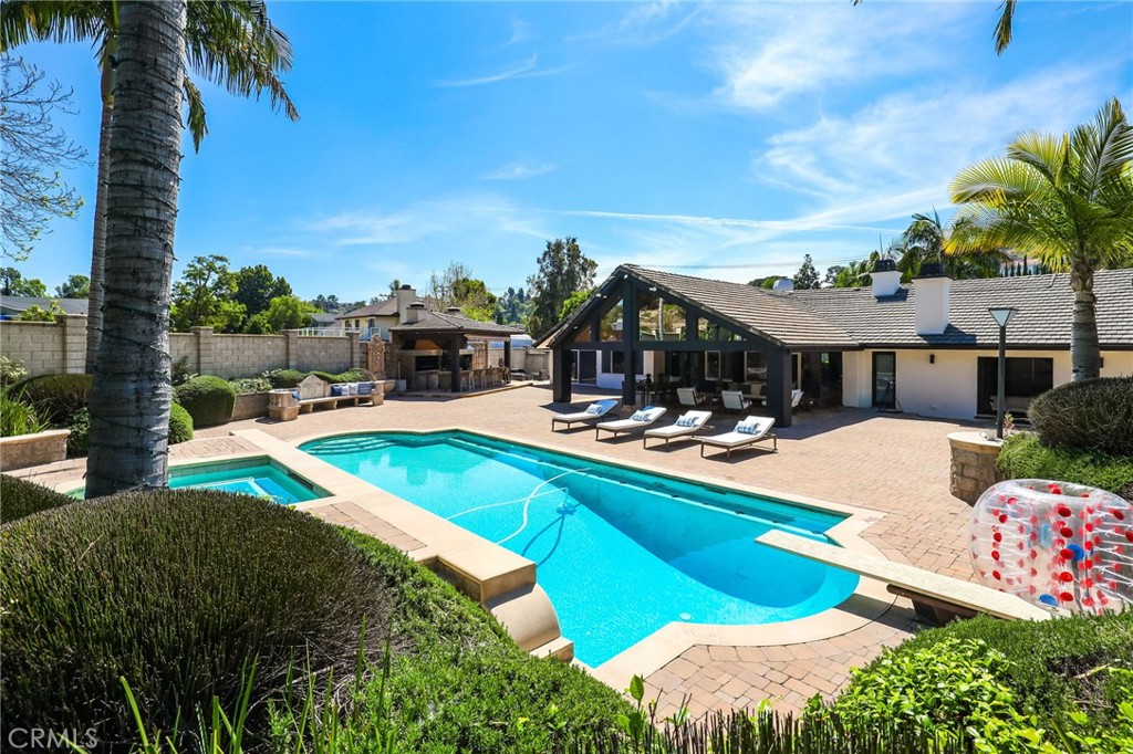10372 South Crawford Canyon Road Santa Ana, CA 92705 - Photo 6 of 75 a view of a swimming pool with lawn chairs under an umbrella