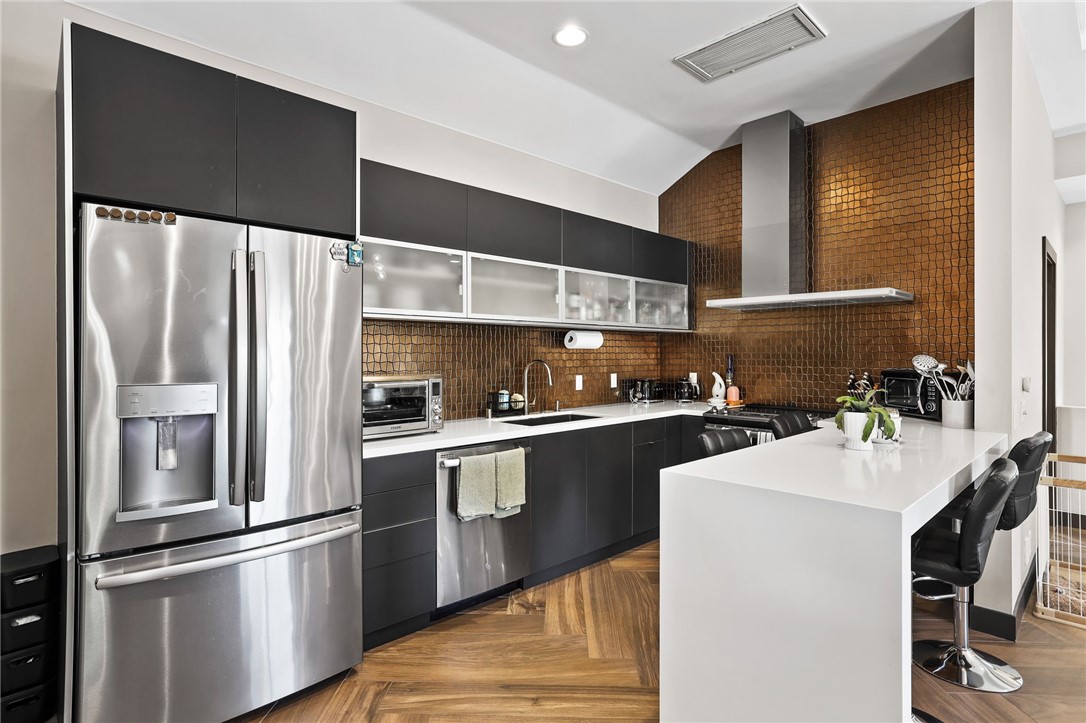 10372 South Crawford Canyon Road Santa Ana, CA 92705 - Photo 69 of 75 a kitchen with stainless steel appliances a refrigerator and a stove top oven