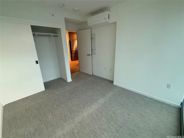 an empty room with closet and mirror