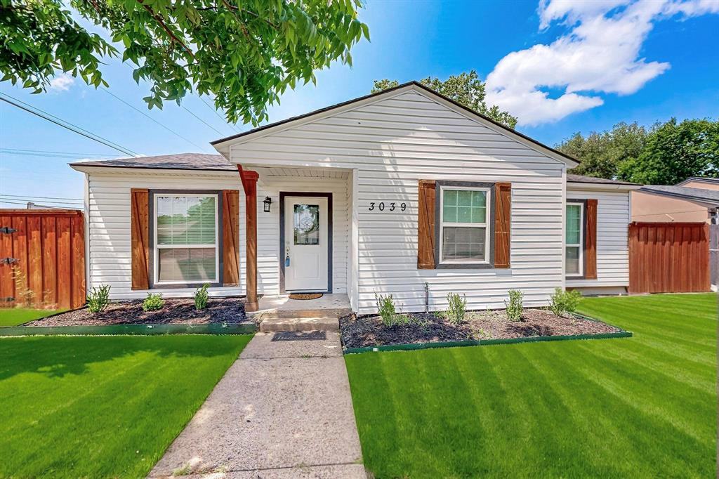 a front view of a house with a garden and yard