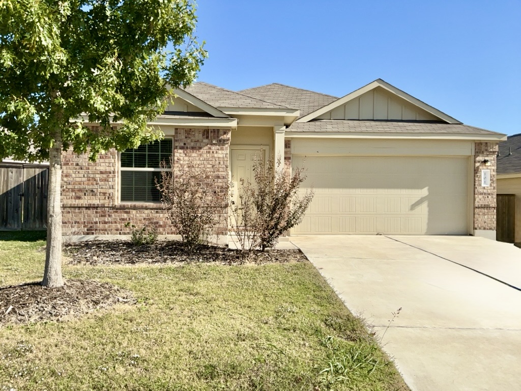 101 COSMOS Lane, Unit 32K Jarrell, TX 76537 - Photo 1 of 20 Ranch-style home with roof with shingles, brick siding, concrete driveway, and an attached garage