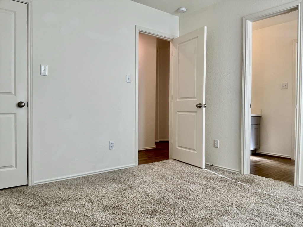 101 COSMOS Lane, Unit 32K Jarrell, TX 76537 - Photo 12 of 20 Bedroom with baseboards and carpet.