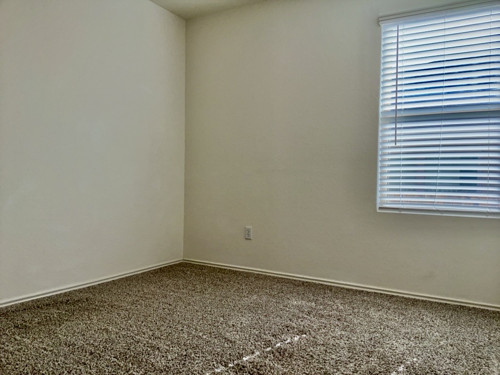 101 COSMOS Lane, Unit 32K Jarrell, TX 76537 - Photo 14 of 20 Carpeted bedroom with baseboards and window.