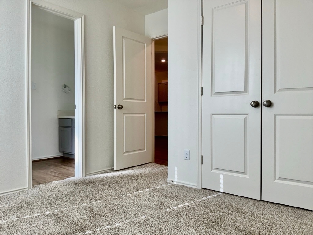101 COSMOS Lane, Unit 32K Jarrell, TX 76537 - Photo 15 of 20 Bedroom featuring a closet, carpet floors, and ensuite bathroom