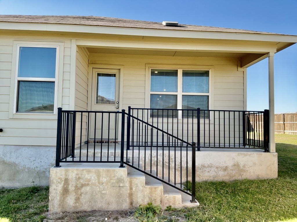 101 COSMOS Lane, Unit 32K Jarrell, TX 76537 - Photo 19 of 20 Covered patio with steps down to fenced backyard.