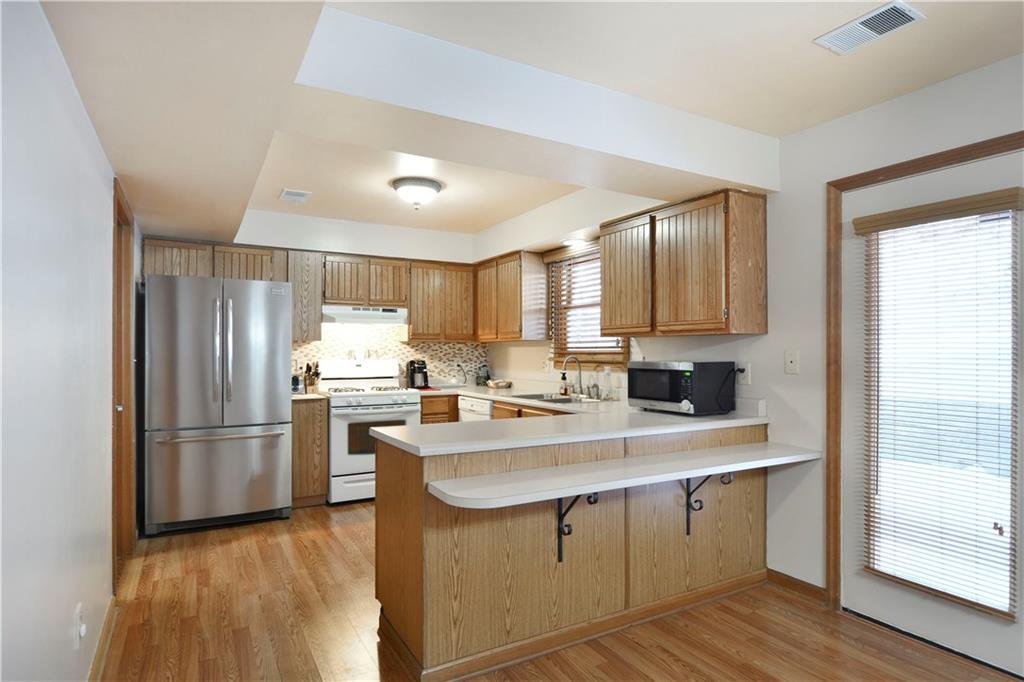 808 Brighton Woods Road Pittsburgh, PA 15212 - Photo 7 of 24 Check out this kitchen...so efficient with its breakfast bar and counter space. The room features upgraded flooring and room for an oversized refrigerator if you wish. The door to the left of the frig provides access to the laundry. The attached garage is just a step down from the laundry.
