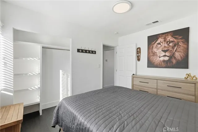 a bedroom with a bed and a painting on the wall