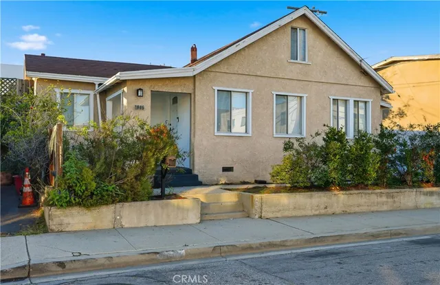 a front view of a house with garage and plants