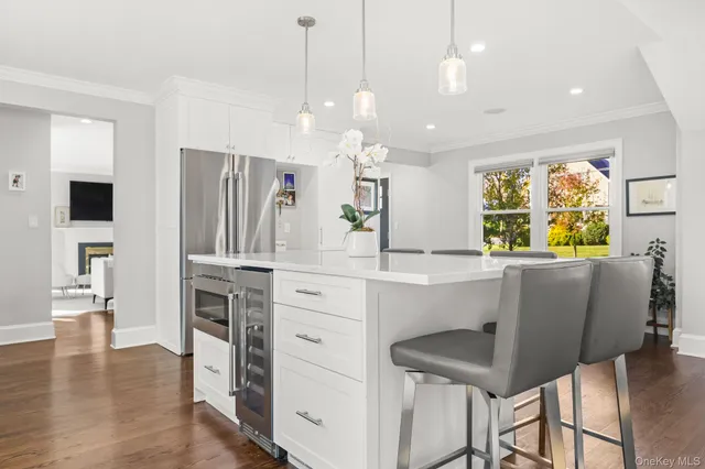 a kitchen with stainless steel appliances kitchen island granite countertop a table chairs and a refrigerator