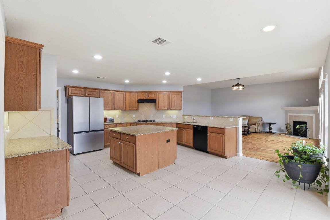 6534 Granbury Road Manvel, TX 77578 - Photo 21 of 49 a large kitchen with stainless steel appliances kitchen island granite countertop a large counter top and a stove top oven