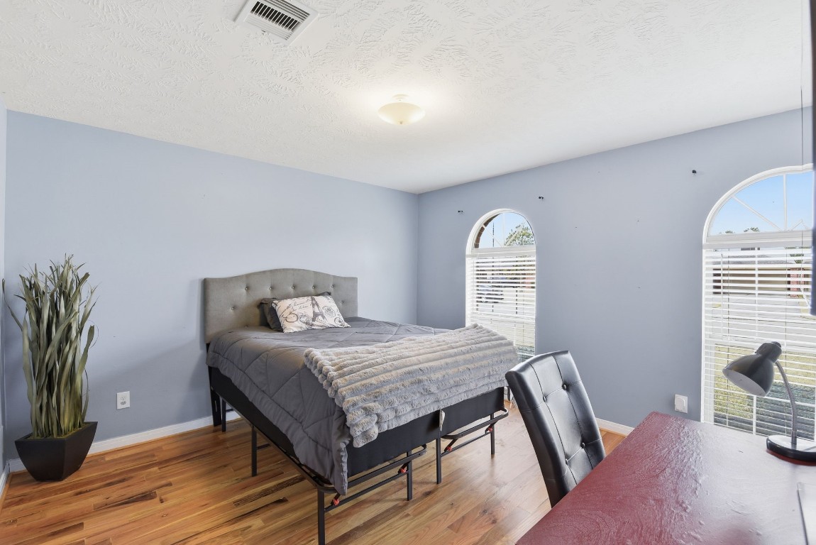 6534 Granbury Road Manvel, TX 77578 - Photo 35 of 49 a bedroom with a bed and wooden floor