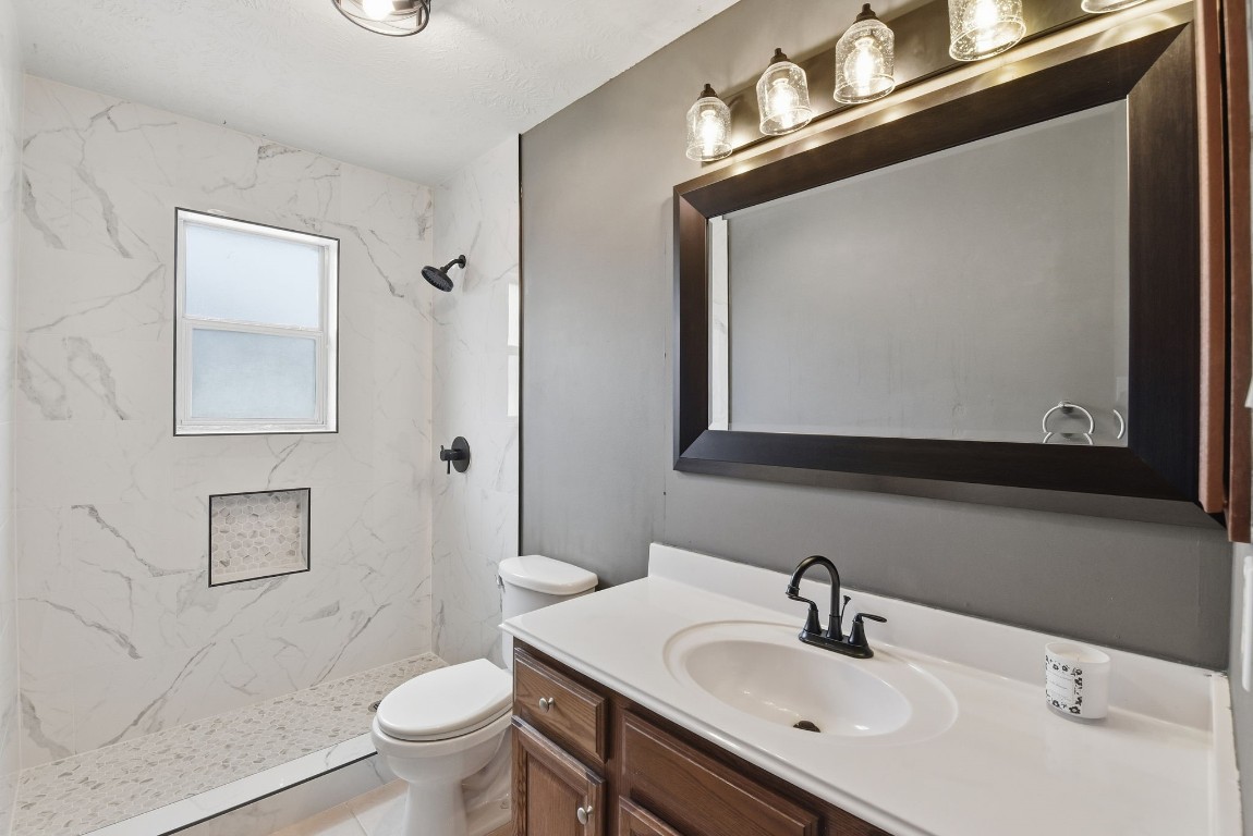 6534 Granbury Road Manvel, TX 77578 - Photo 37 of 49 a bathroom with a toilet sink and mirror