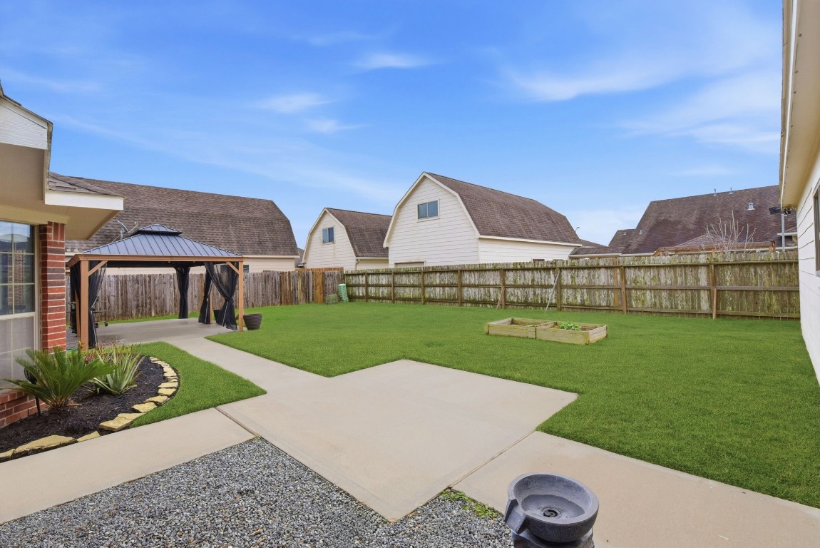 6534 Granbury Road Manvel, TX 77578 - Photo 42 of 49 a view of a house with garden space and a car parked in front of it