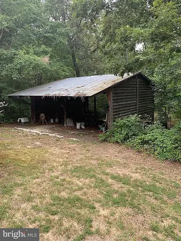 a backyard of a house with large trees and barbeque oven
