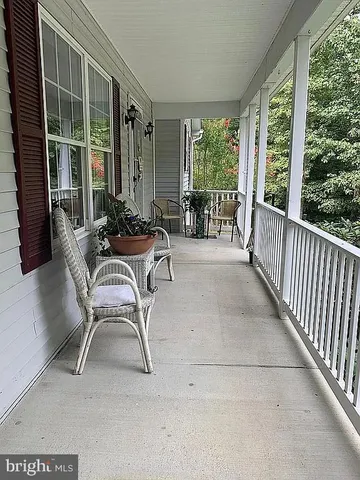 a view of a patio with table and chairs and floor to ceiling window