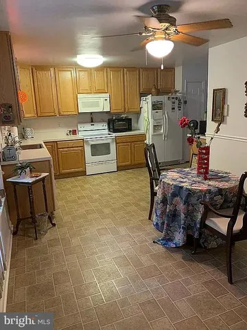 a kitchen with kitchen island granite countertop a stove a sink a dining table and chairs