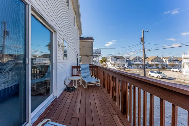 a view of a balcony with chairs and wooden floor