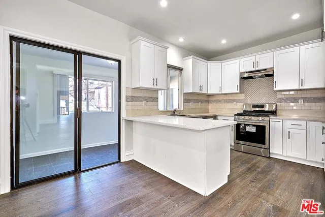 a kitchen with a refrigerator and a stove top oven