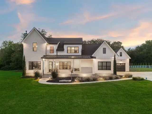 a front view of a house with a garden and yard