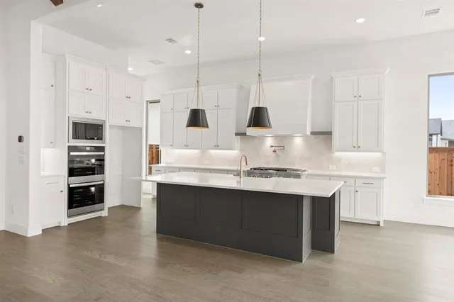 a kitchen with stainless steel appliances granite countertop a sink and a stove