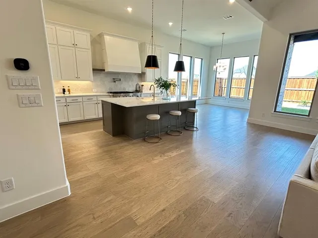 a kitchen with stainless steel appliances a sink a stove a refrigerator and cabinets