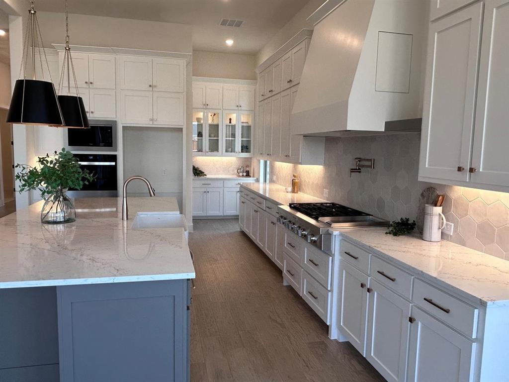 4416 Meander Way Prosper, TX 75078 - Photo 6 of 40 a kitchen with stainless steel appliances a sink a stove a refrigerator and cabinets
