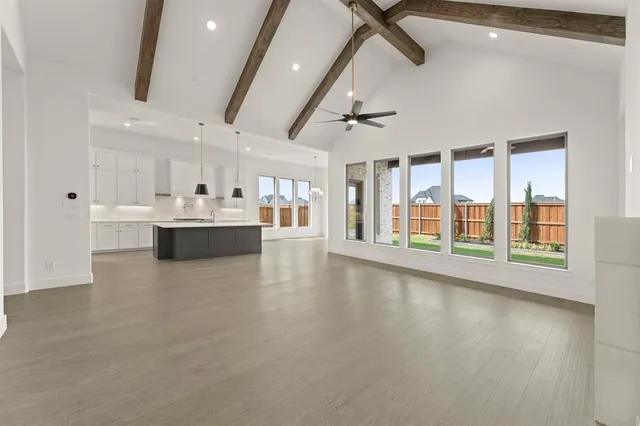 a view of a kitchen with kitchen island and stainless steel appliances