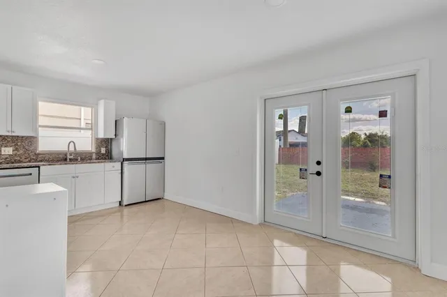 a kitchen with white cabinets and refrigerator