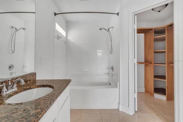 a bathroom with a granite countertop sink mirror and shower