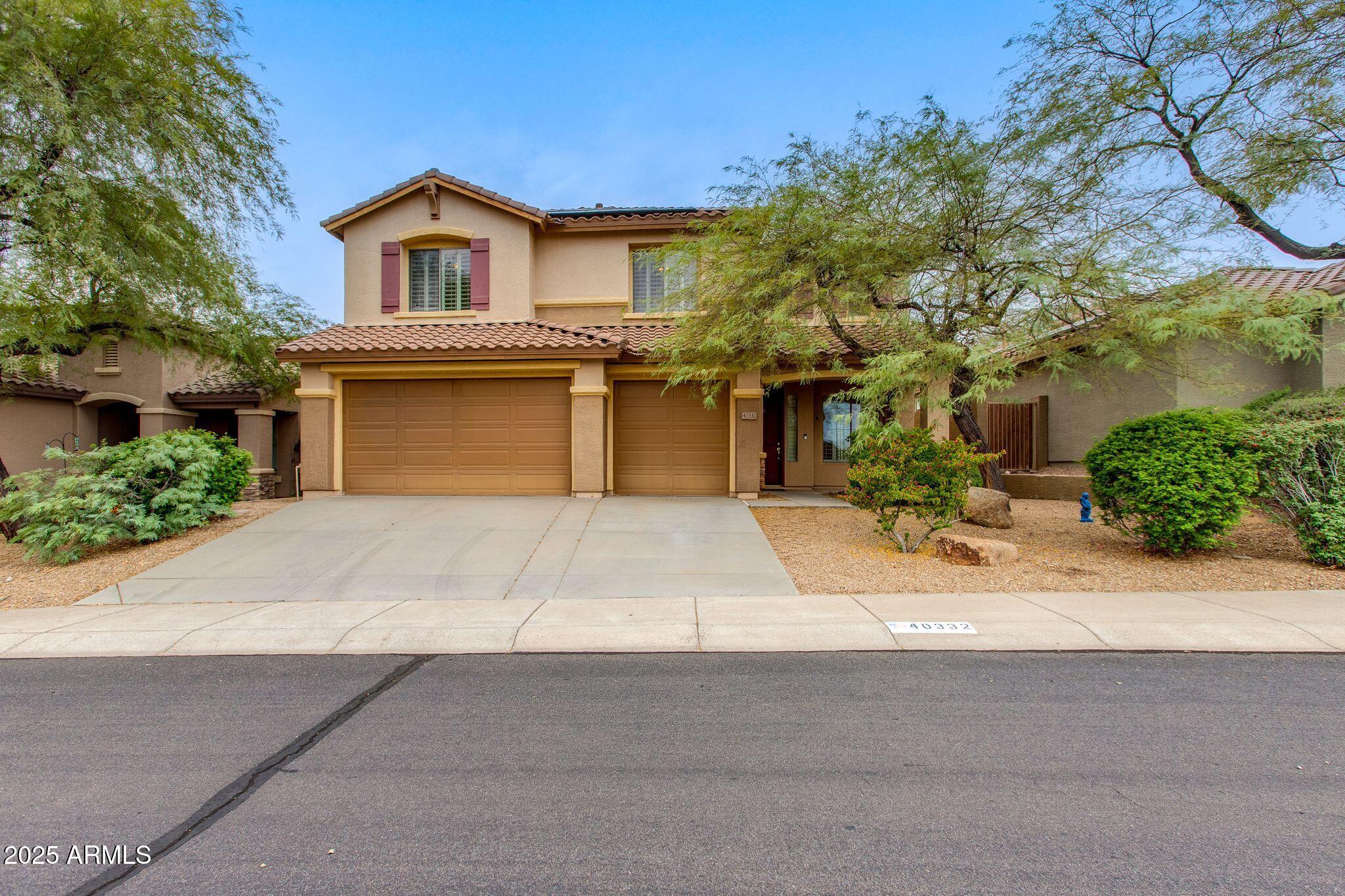 40332 North High Noon Way Phoenix, AZ 85086 - Photo 1 of 25 a front view of a house with a yard and garage