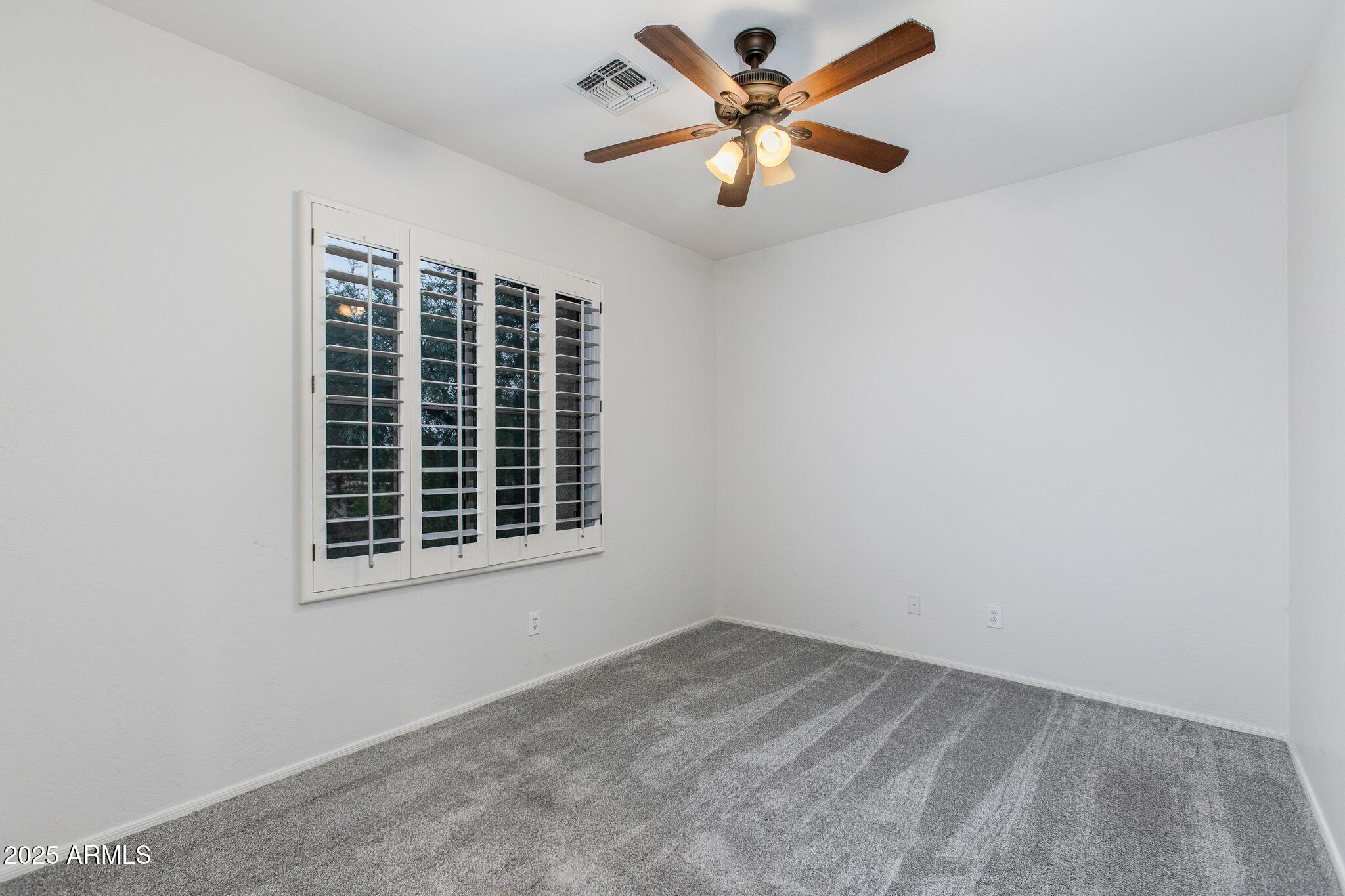 40332 North High Noon Way Phoenix, AZ 85086 - Photo 14 of 25 an empty room with a window and a fan