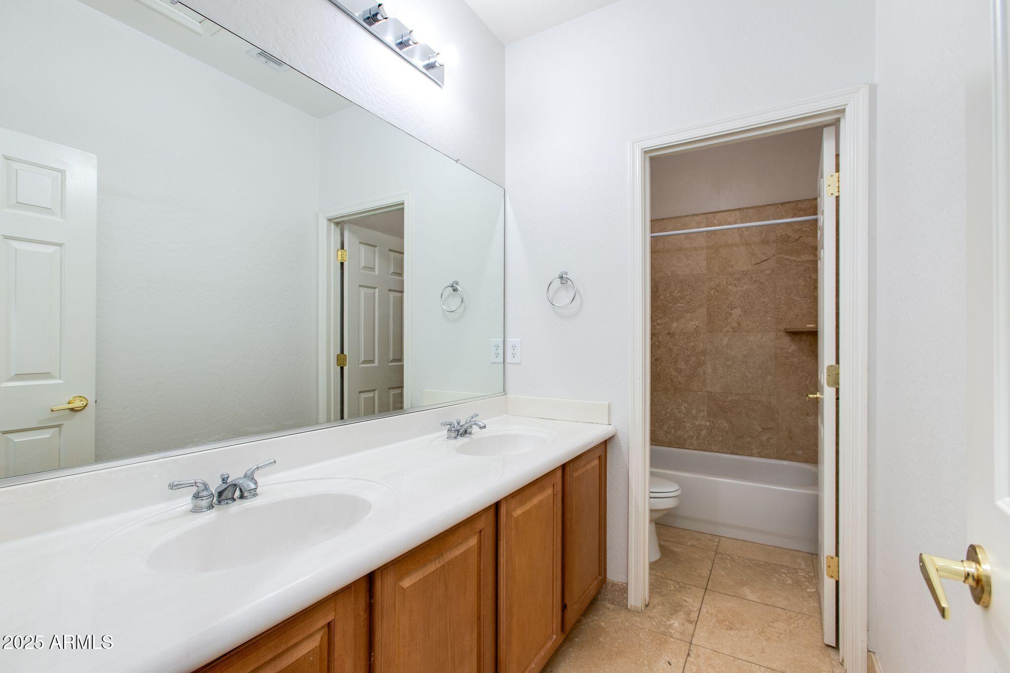 40332 North High Noon Way Phoenix, AZ 85086 - Photo 16 of 25 a bathroom with a tub sink vanity and a mirror