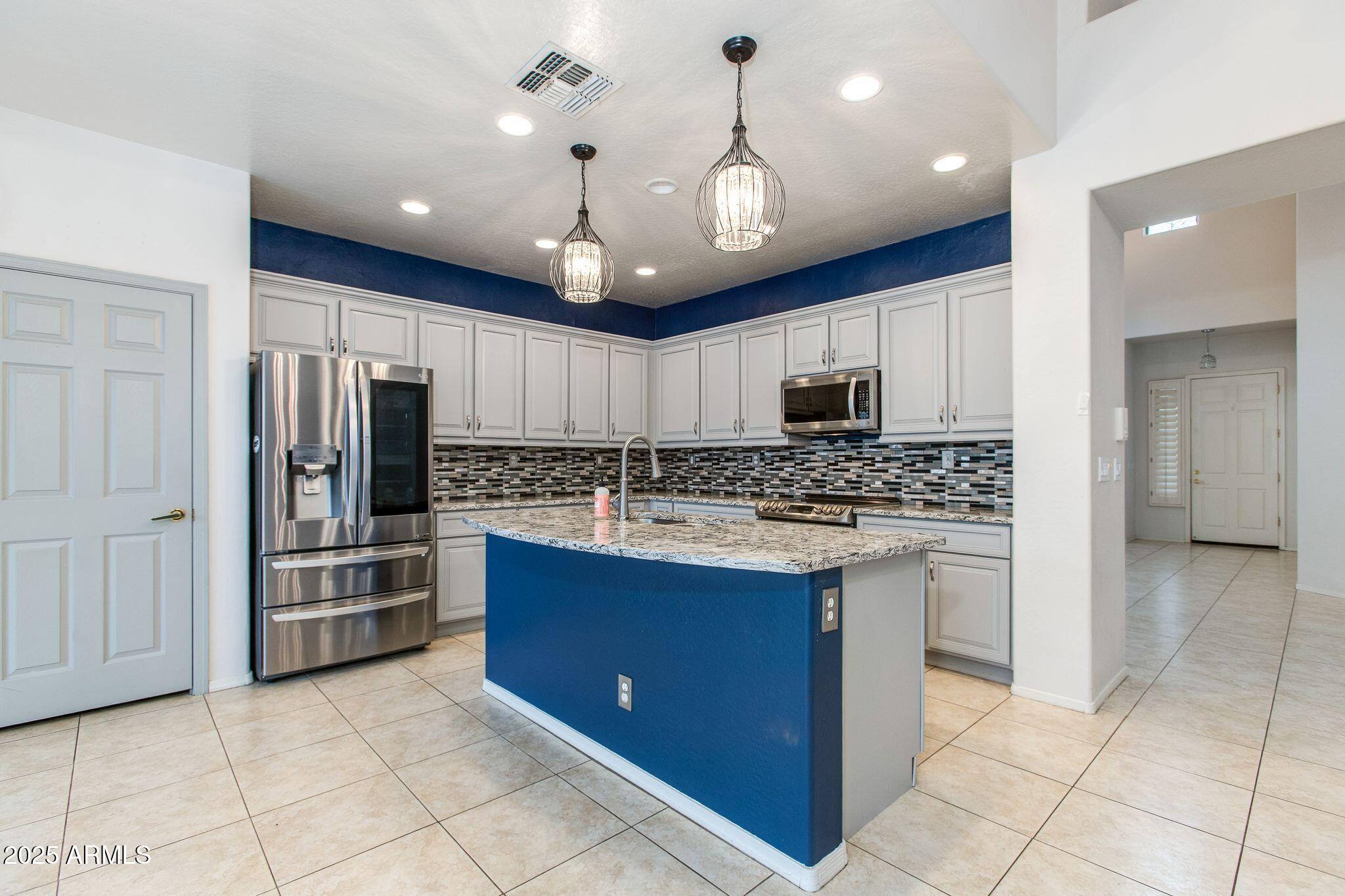 40332 North High Noon Way Phoenix, AZ 85086 - Photo 3 of 25 a kitchen with stainless steel appliances granite countertop a refrigerator and a stove top oven