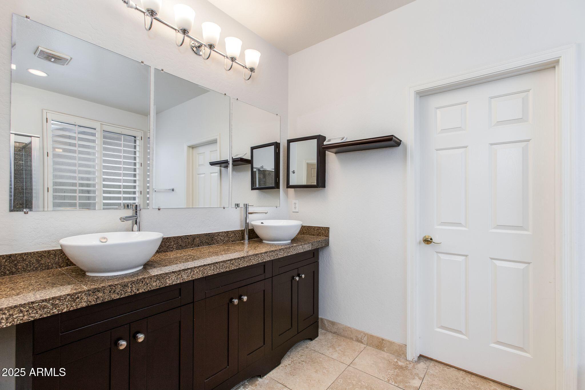 40332 North High Noon Way Phoenix, AZ 85086 - Photo 7 of 25 a spacious bathroom with a granite countertop sink a toilet and mirror