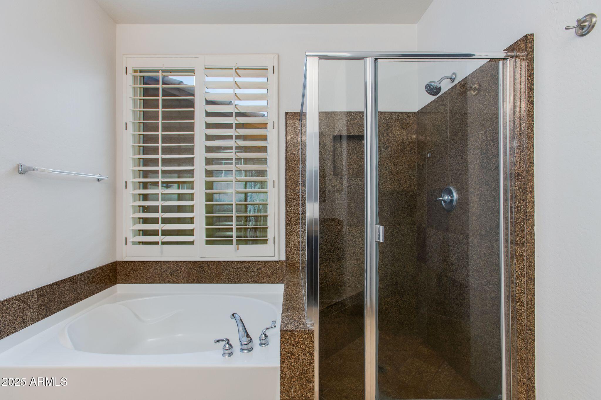 40332 North High Noon Way Phoenix, AZ 85086 - Photo 8 of 25 a bathroom with a bathtub and shower