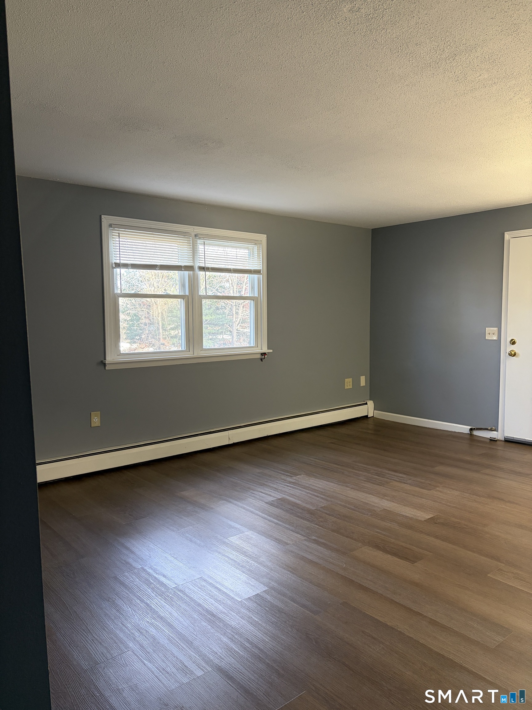 270 South Windham Road, Unit 63 Willimantic, CT 06226 - Photo 12 of 18 an empty room with wooden floor and windows