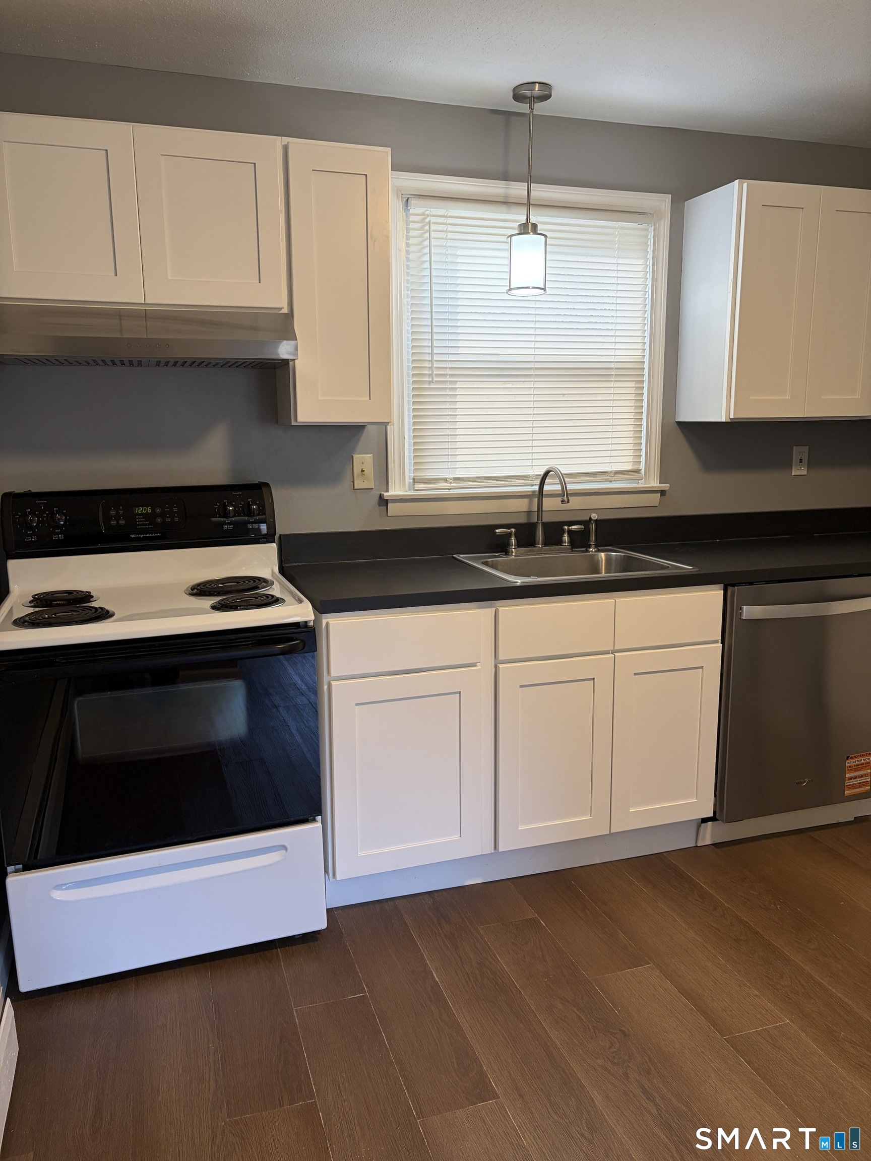270 South Windham Road, Unit 63 Willimantic, CT 06226 - Photo 2 of 18 a kitchen with granite countertop white cabinets and a stove with wooden floor