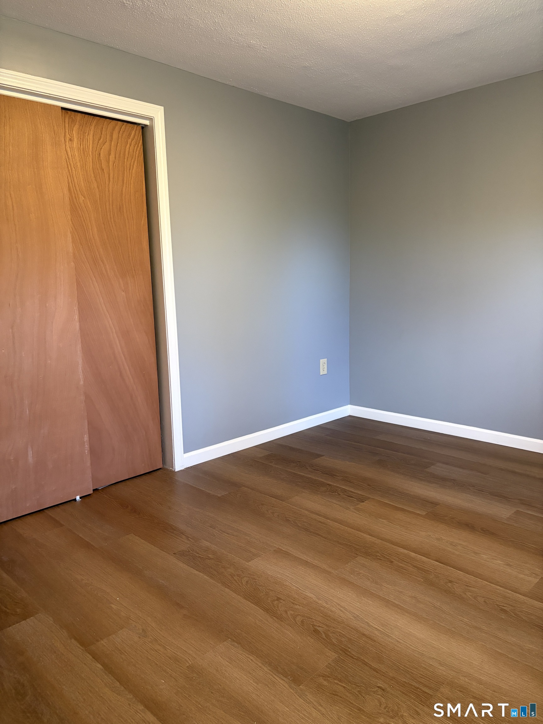 270 South Windham Road, Unit 63 Willimantic, CT 06226 - Photo 9 of 18 a view of an empty room with wooden floor and a window