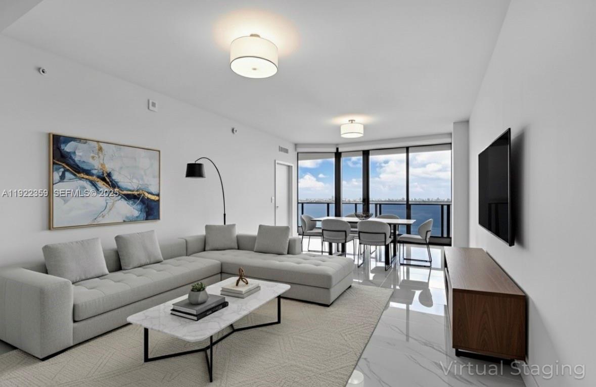 700 Northeast 24th Street, Unit 2003 Miami, FL 33137 - Photo 16 of 87 a living room with furniture a large window and a flat screen tv
