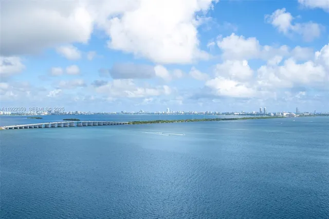 a large white kitchen with a sink and stainless steel appliances