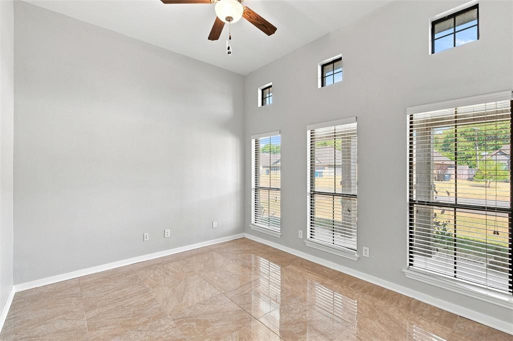 10409 Condor Loop Waco, TX 76708 - Photo 4 of 26 High vaulted ceiling with a ceiling fan, multiple transom windows, and full-height windows, complemented by large format tile flooring