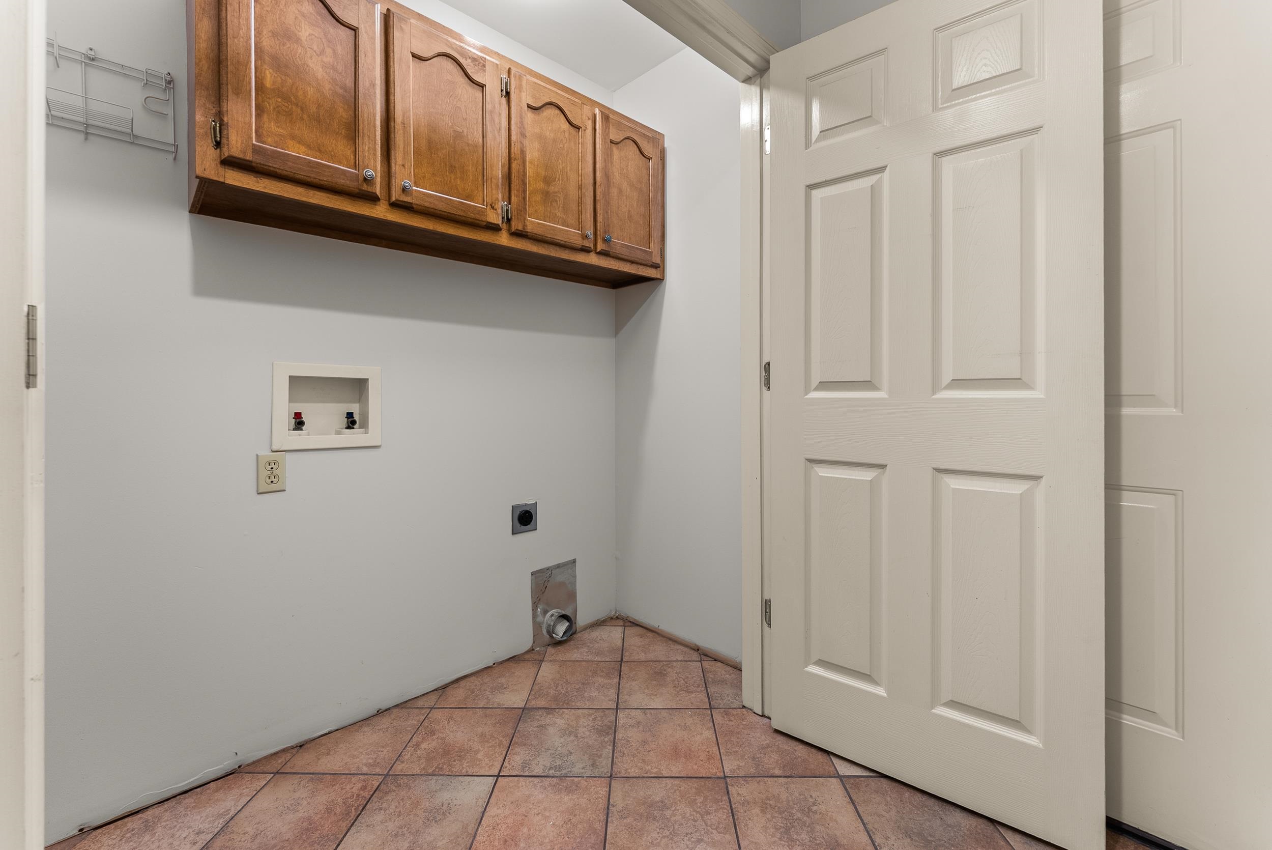 139 Melrose Road Covington, TN 38019 - Photo 16 of 19 Laundry area featuring cabinet space, hookup for a washing machine, light tile patterned floors, and hookup for an electric dryer