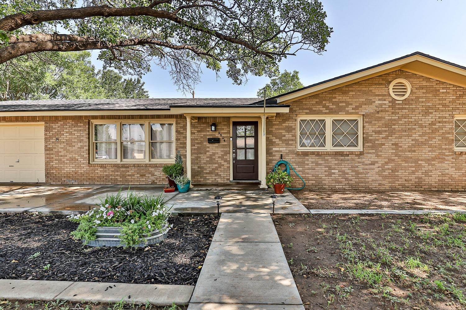 3604 48th Street Lubbock, TX 79413 - Photo 2 of 50 a front view of a house with garden
